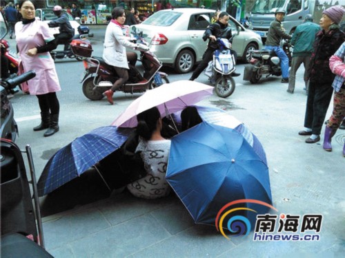 海口女子路邊產子,雨傘做產房